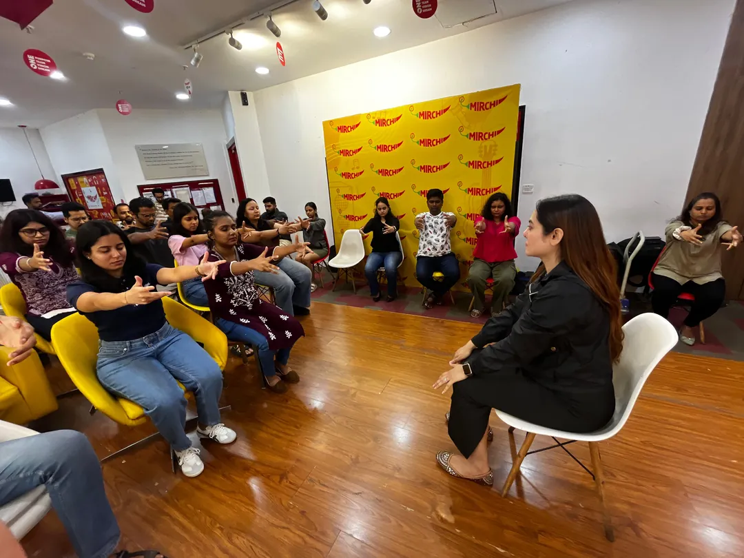 Vibha Jain leading a group hypnotherapy session with participants seated in a circle around her